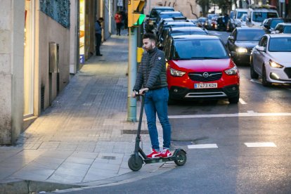 Un noi circula en patinet elèctric pel centre de Tarragona.