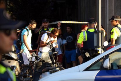 Los agentes alzan el cordón policial para que salgan los ciudadanos confinados por el atentado terrorista en el centro de Barcelona, el 17 de agosto de 2017.