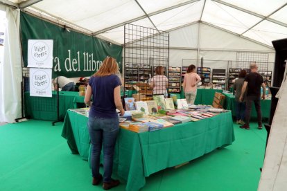 La carpa de la Fira del Llibre Ebrenc con los libreros acabando de prepararla en las primeras horas de la muestra.