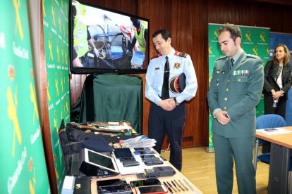 El capitán de la Guardia Civil, Gerardo Suárez, y el inspector de los Mossos d'Esquadra, Jordi Salvia, observan algunos de los objetos sustraídos, en la sede de la Guardia Civil en Huesca