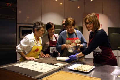 Un grupo de mujeres cocinando canelones.