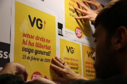 Enganxada de cartells de la vaga del 21-F a la seu de l'ANC.