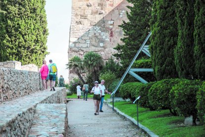 Diverses persones, durant la visita al Passeig Arqueològic aquest diumenge al migdia.