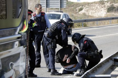 Pla obert del noi detingut pels Mossos d'Esquadra, d'esquenes i emmanillat, a les proximitats del peatge de l'AP-7 a Tarragona. Imatge del 21 de febrer del 2019