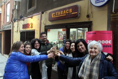 Imatge d'un brindis amb cava davant l'estanc de Montblanc que ha venut dos bitllets del 22418, el segon premi de la Grossa de Cap d'Any, amb la propietària Teresa Haya a la dreta