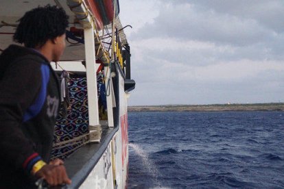 Un menor a bord de l'Open Arms espera el desembarcament del vaixell.