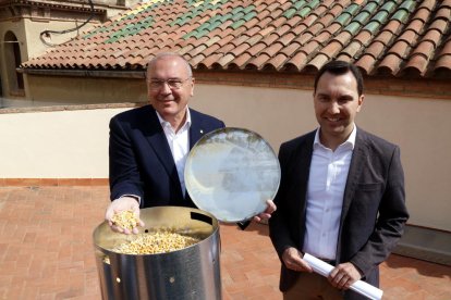 El alcalde de Reus, Carles Pellicer, y el concejal de Medio Ambiente, Daniel Rubio, al lado de un dispensador de pienso anticonceptivo para palomas que, durante unos días, tirará maíz.