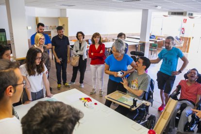 Dos chicos de la Associació 'La Muntanyeta' sonríen después de recibir los proyectos de los estudiantes.