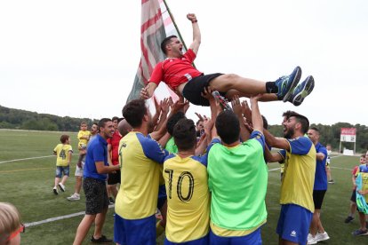 Els jugadors del Catllar celebrant l'ascens i mantejant al tècnic de l'equip.