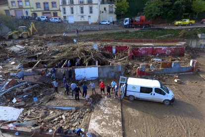 Imatge d'una cadena humana de persones extraient ampolles de vi de les runes del Celler Rendé de Masdéu