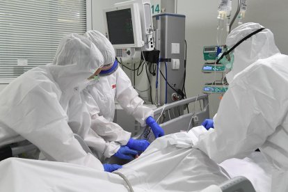 Plano medio de los sanitarios con un paciente en la UCI del Hospital de Manresa.