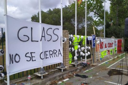 Exterior de la fábrica Saint-Gobain en l'Arboç, lleno de pancartas y cascos pidiendo detener el cierre de la división Glass.