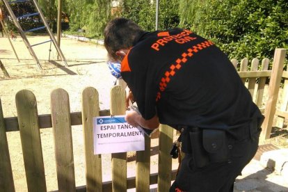 Imagen de un técnico de Protección Civil retirando los carteles de cierre temporal.