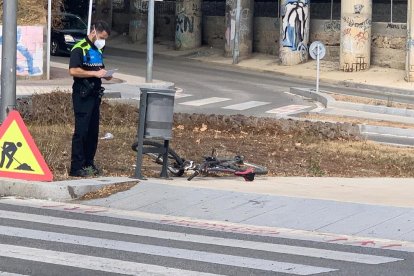 Un agente de la Guardia Urbana observando la bicicleta accidentada.