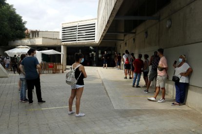 Pla obert on es pot veure una cua de veïns per fer-se la prova PCR al cribratge massiu per trobar asimptomàtics de covid-19 al barri de Balàfia de Lleida