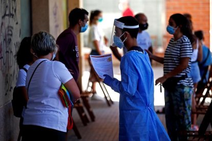 Professionals sanitaris informen a les persones interessades a fer-se PCR.