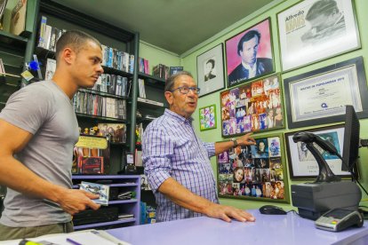 Paco Soler, con su hijo Àlex, muestra algunos de los autógrafos firmados por figuras de la canción.