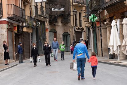 Varias personas paseando por una calle.