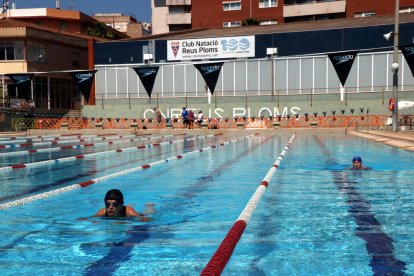 Dues dones nedant a la piscina exterior de 50 metres del Club Natació Reus Ploms.