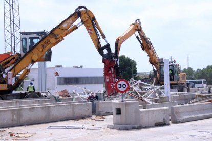 Dues màquines treballant en la retirada de les estructures del peatge de l'Aldea de l'AP-7.