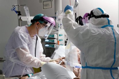 Personal sanitario atendiendo a un paciente en una UCI.