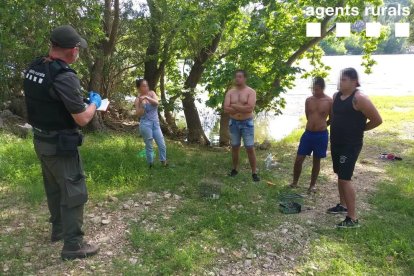 Pla general d'un agent rural amb les quatre persones denunciades per caçar ocells amb vesc a Tivenys.