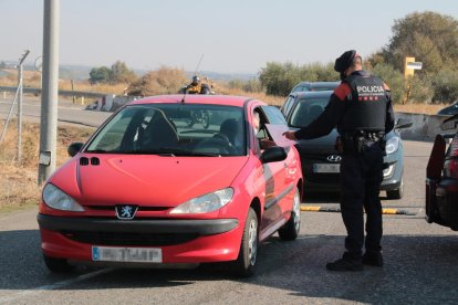 Una gent de l'ARRO dels Mossos d'Esquadra demanant tornant a un conductor un certificat d'autoresponsabilitat, durant un control a l'antiga N-II, al terme municipal d'Alcarràs