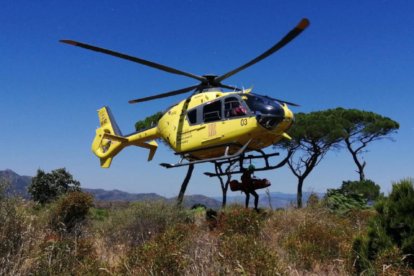 Un Bomber dels GRAE amb la llitera carregant l'home a l'helicòpter del SEM