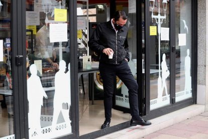 Un cliente de una cafetería llevándose un café porque el establecimiento está cerrado.