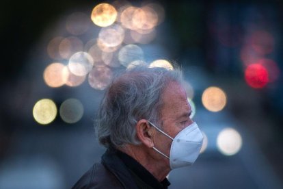 Una persona con mascarilla por la calle.