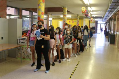 Una professora i un grup d'alumnes de l'Escola Catalònia de Barcelona caminant ordenats pel passadís