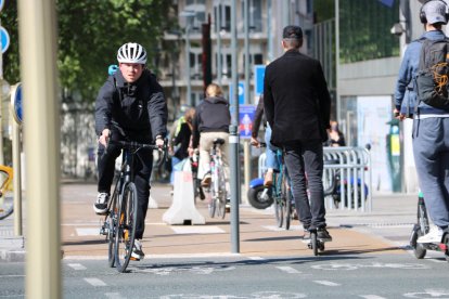 Un ciclista y un chico en patinete circulando por el centro de Bruselas durante la primera semana de desconfinamiento