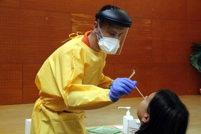 Un sanitario haciendo una prueba PCR a un vecino del barrio de Balàfia de Lleida.