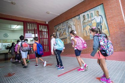 Varios niños en la entrada de una escuela el primer día de clase.