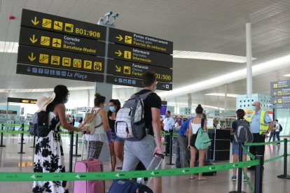 Plano general de pasajeros haciendo cola para acceder a la T1 del Aeropuerto del Prat.