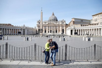 Imatge de turistes davant la plaça de Sant Pere, gairebé buida, a Roma.