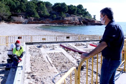 L'alcalde de l'Ametlla de Mar, Jordi Gaseni, observant les obres de reconstrucció de la plataforma de dutxes de la platja de Pixa-vaques.