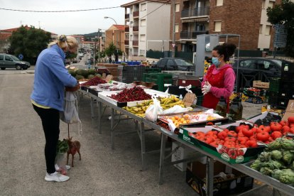 Una compradora i una venedora en una de les parades obertes del mercat de Coma-ruga del Vendrell.