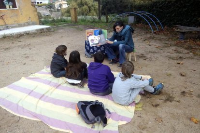 Un grup d'escolars fent classe a un parc infantil públic.