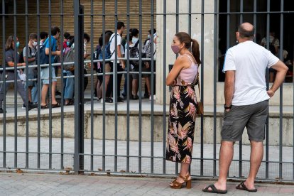 Una pares mirant com els alumnes accedeixen a un centre escolar.