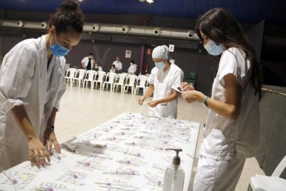 Professionals sanitaris es preparen per fer el cribratge de coronavirus a l'Espai Mercat de Tàrrega.