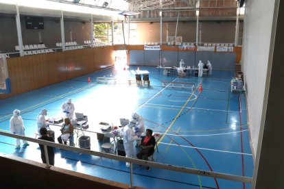 Pla general del personal sanitari fent proves PCR en el primer dia del cribratge massiu al pavelló de Santa Eugènia