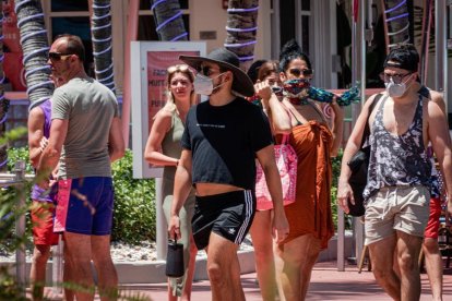 Persones usant mascareteres passegen, el 3 de juliol del 2020, en el passeig turístic de Ocean Drive a Miami Beach, Florida.