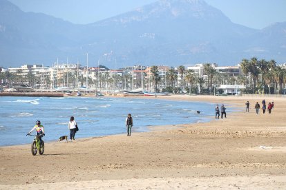 La platja de Salou i de persones passejant-hi, en ple hivern.