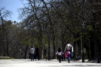 Una madre anda con su hija por un parque de Madrid