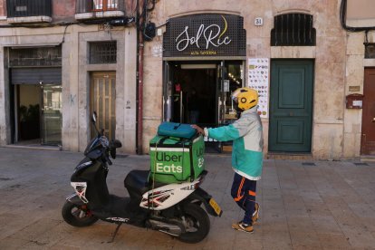 Pla general d'un repartidor a domicili esperant la comanda.