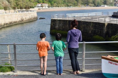 Una dona passeja amb els seus fills pel Port Vell de Getxo (Bizkaia), aquest diumenge en el qual es compleixen 43 dies de confinament i en el qual més de sis milions de nens menors de 14 anys poden sortir al carrer una hora al dia, al costat d'un adult i a un quilòmetre com a màxim de les seves cases.