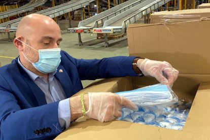 Un representante de la subdelegación revisando una de las cajas de mascarillas entregadas por el gobierno español en Cataluña.