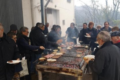 Los participantes disfrutando de longaniza y pan tostado.