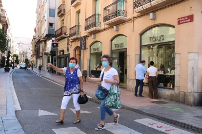 Vianants travessant al raval de Santa Anna de Reus on hi ha accés restringit de vehicles.